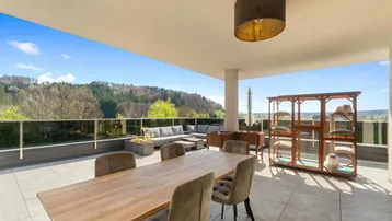 Weitläufige Dachterrasse mit Essbereich, Lounge-Möbeln und Panoramablick.