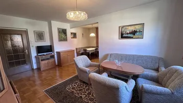 Helles Wohnzimmer mit Parkettboden, traditioneller Einrichtung und Kronleuchter.