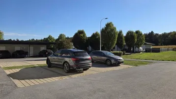 Außenparkplätze mit ausreichend Stellfläche für mehrere Fahrzeuge in grüner Umgebung.