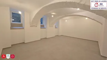 Geräumiger Kellerraum mit charakteristischen Gewölbedecken und hellen Fliesenböden, frisch renoviert.