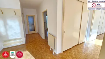 Heller Eingangsbereich mit Parkettboden, Garderobe und praktischen Einbauschränken für Stauraum.