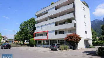 Mehrstöckiges Wohngebäude mit Balkonen und Blick auf die umliegende Berglandschaft.