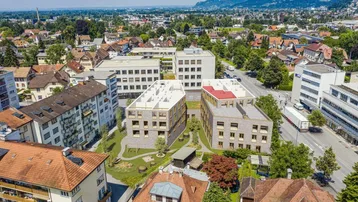 Luftaufnahme eines Neubauprojekts mit modernen Gebäuden in einer Wohngegend mit Bergblick.