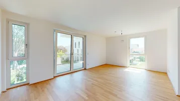 Helles, leeres Wohnzimmer mit Holzboden und Zugang zu einem Balkon, bereit zum Einzug.