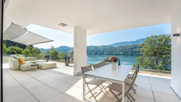 Geräumige Terrasse mit Esstisch, Lounge-Bereich und atemberaubendem Seeblick.