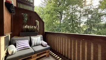 Gemütlicher Balkon mit selbstgebauten Palettenmöbeln und einem schönen Blick ins Grüne.