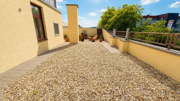 Geräumige Dachterrasse mit Kiesbelag, bietet viel Platz für individuelle Gestaltung und sonnige Stunden.