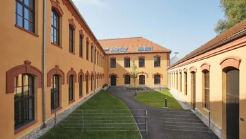 Innenhof des Studentenwohnheims mit gepflegtem Rasen, Gehwegen und der historischen Gebäudefassade.
