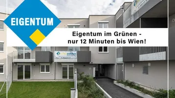 Modernes Wohngebäude mit Balkonen, begrüntem Außenbereich und Zugangsweg mit Rampe.