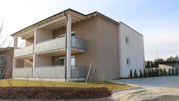 Neues Wohngebäude mit mehreren Balkonen und gepflegter Außenanlage in sonniger Lage.
