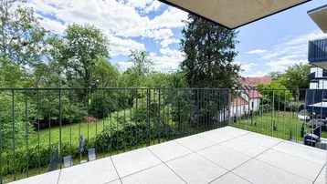 Geräumiger Balkon mit Fliesenboden und weitem Blick ins Grüne, ideal zum Entspannen.