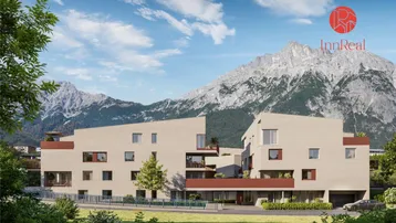 Moderne Wohnanlage mit klarer Architektur und beeindruckendem Bergblick im Hintergrund.