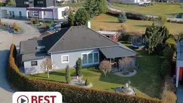 Luftaufnahme eines Einfamilienhauses mit großem Garten und umliegender Wohnbebauung.
