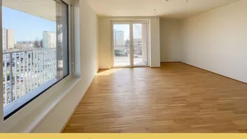 Helles Wohnzimmer mit Parkettboden, großen Fenstern und Zugang zum Balkon mit Stadtblick.