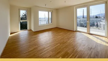 Helles Wohnzimmer mit Parkettboden, großen Fenstern und Zugang zu einem Balkon mit Stadtblick.