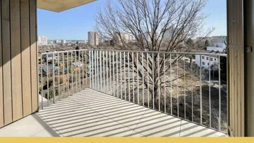 Geräumiger Balkon mit Fliesenboden und weitem Blick über die Stadt und grüne Umgebung.