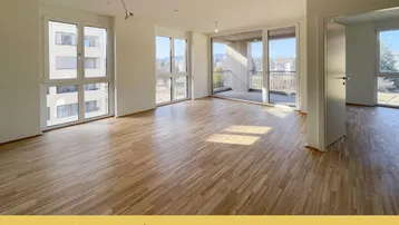 Helles Wohnzimmer mit Parkettboden, großen Fenstern und Zugang zu einem sonnigen Balkon.