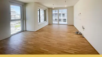 Helles, unmöbliertes Wohnzimmer mit großen Fenstern und Holzboden, bereit für die individuelle Gestaltung.