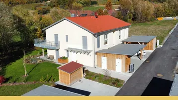 Neubau-Doppelhaushälfte mit Garten, Balkon und Carport in ländlicher Umgebung.