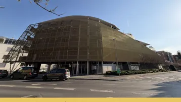 Modernes Gebäude mit markanter Fassadenverkleidung und umliegender Straße in Graz.