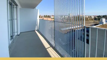 Geräumiger Balkon mit modernem Metallgeländer und weitem Blick unter blauem Himmel.