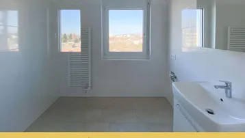 Helles Badezimmer mit Fliesenboden, Fenster, modernem Waschtisch und Handtuchheizkörper.