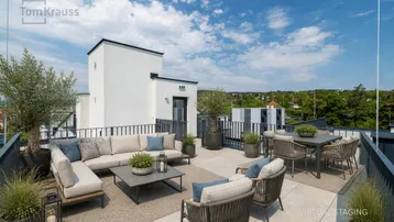 Geräumige Dachterrasse mit bequemen Loungemöbeln und Essbereich unter blauem Himmel.
