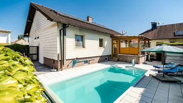 Außenansicht des Hauses mit einem einladenden Swimmingpool und sonniger Terrasse.