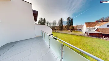 Geräumiger Balkon mit Fliesenboden und Blick auf die grüne Umgebung und Nachbarhäuser.