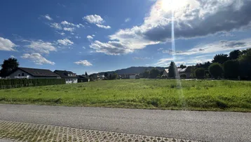 Sonniges Grundstück mit weitem Blick auf die umliegende Landschaft und Berge.