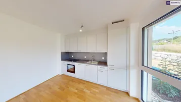 Moderne Einbauküche mit hellen Fronten und Blick ins Grüne durch große Fenster.