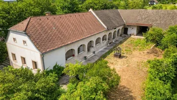 Luftaufnahme des Anwesens mit mehreren Gebäuden und einem großen, ungenutzten Innenhof.