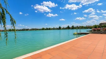 Geräumige Terrasse mit Terrakottafliesen und direktem Zugang zum See mit weitem Blick.