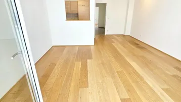 Helles Wohnzimmer mit Holzboden und Blick in die Küche, ideal für offenes Wohnen.