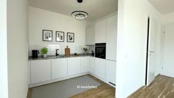 Moderne Küche mit weißen Schränken, integriertem Backofen und Holzboden, hell und funktional.