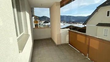 Geräumiger Balkon mit Fliesenboden und Blick auf die verschneite Berglandschaft.