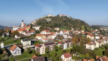 Luftaufnahme der Stadt mit Burg auf dem Hügel und den neuen Wohngebäuden in die Landschaft integriert.
