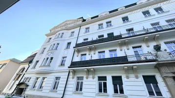 Elegante Fassade eines historischen Gebäudes mit mehreren Balkonen und klassischen architektonischen Details.