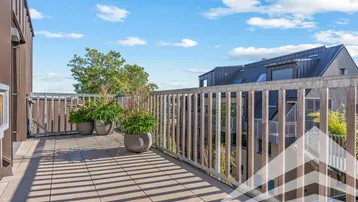Großzügige Dachterrasse mit Fliesenboden und weitem Blick über die Dächer.