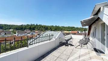 Weitläufige Dachterrasse mit Sitzgelegenheiten und Panoramablick über die Nachbarschaft und grüne Hügel.