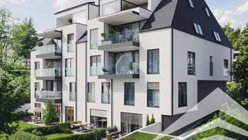 Moderne Wohnanlage mit weißer Fassade, Balkonen, Terrassen und gepflegter Grünanlage.