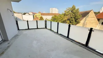 Geräumige Terrasse mit moderner Milchglasbrüstung und weitem Blick auf die Stadt und Umgebung.