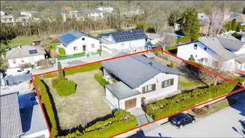 Luftaufnahme eines Einfamilienhauses mit Garten und roter Grundstücksumrandung in einer Wohnsiedlung.