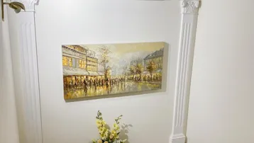 Treppenhaus mit dekorativer Wandgestaltung, Kunstwerk und Stuckelementen.