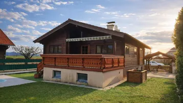 Traditionelles Holzhaus mit Balkon, Garten und Carport unter einem sonnigen Himmel.