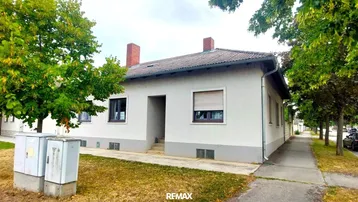 Einfamilienhaus mit schlichter Fassade, Rollläden und Vorgarten in einer ruhigen Wohngegend.