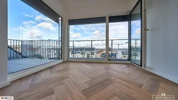 Helles Zimmer mit Fischgrätparkett, großen Fenstern und Zugang zu einer Terrasse mit Stadtblick.