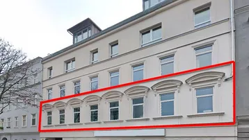 Historisches Gebäude mit renovierter Fassade, großen Fenstern und einem Geschäft im Erdgeschoss.