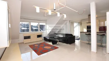 Helles und offenes Wohn-Esszimmer mit Dachschrägen, Fliesenboden und Blick auf die Stadt.