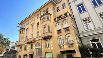Historisches Altbaugebäude mit charakteristischen Erkern und Balkonen an einer städtischen Straße.